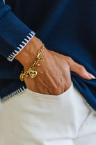 Close up of a 18k Gold Plated Waterproof Stainless Steel Bracelet with Heart and dot charms on a woman's wrist.