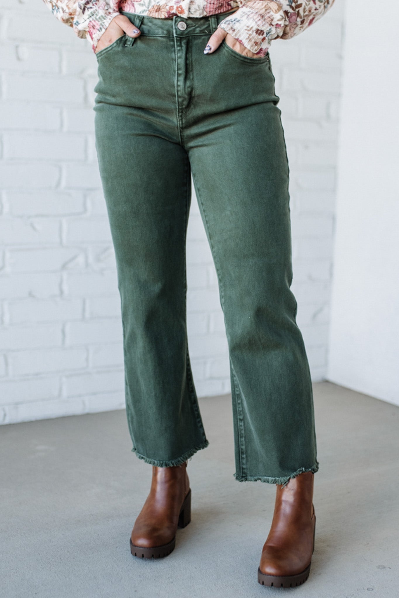 Dark green denim jeans with frayed hemline.