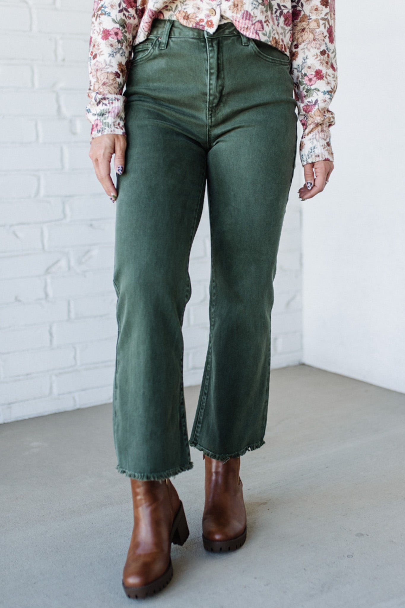 Dark green denim jeans with frayed hemline.