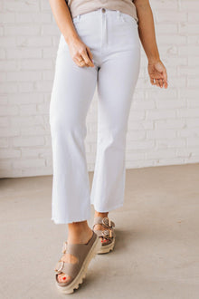  Woman wearing white cropped jeans with chunky tan sandals.