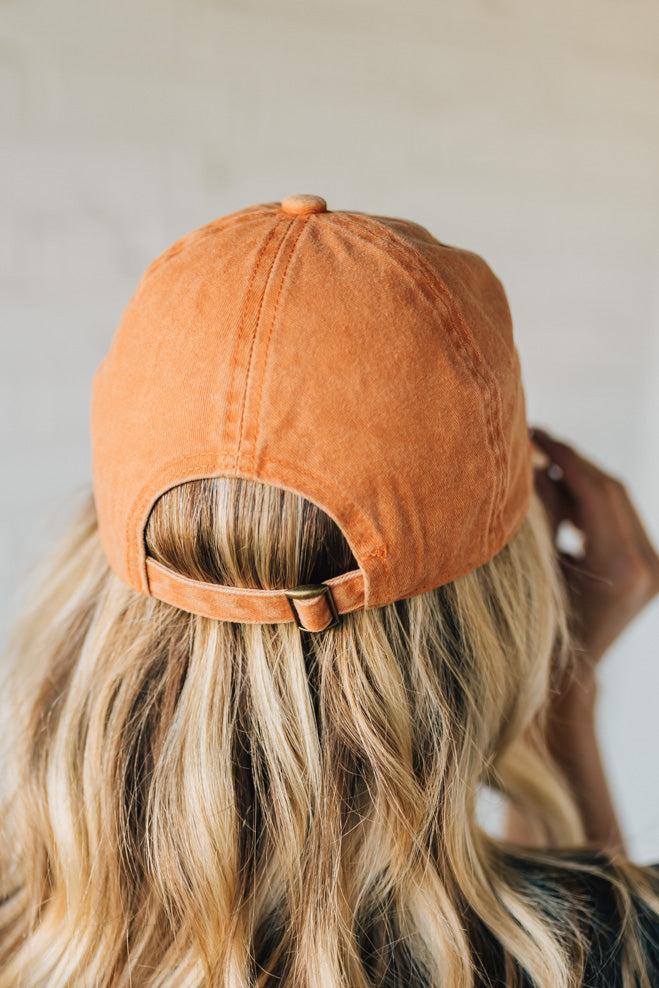 Person wearing an orange baseball cap with a blurred background