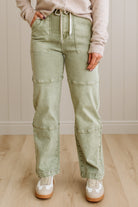 Person wearing light green cargo pants with a neutral background