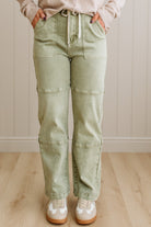 Person wearing light green cargo pants with a neutral background