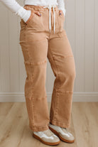 Person wearing tan cargo pants with a white background