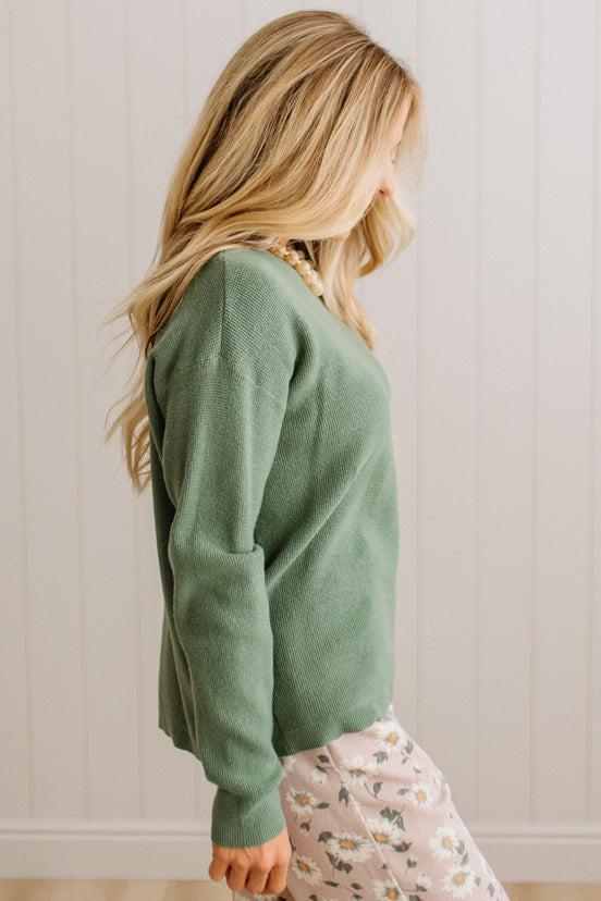 Blonde woman wearing a solid waffle texture sweater with drop shoulder seams and crewneck.