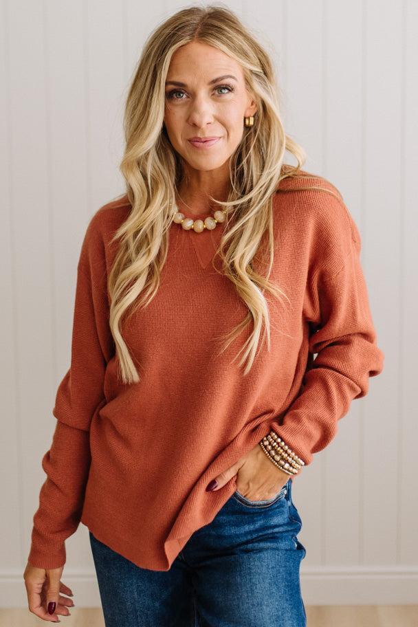 Blonde woman wearing a solid waffle texture sweater with drop shoulder seams and crewneck.