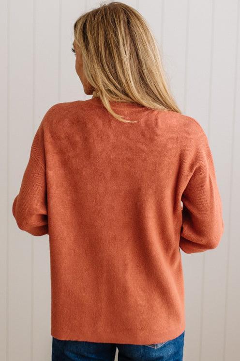 Blonde woman wearing a solid waffle texture sweater with drop shoulder seams and crewneck.