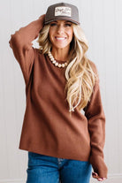 Blonde woman in a plaid hat wearing a solid waffle texture sweater with drop shoulder seams and crewneck.