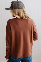 Blonde woman in a plaid hat wearing a solid waffle texture sweater with drop shoulder seams and crewneck.
