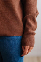 Blonde woman in a plaid hat wearing a solid waffle texture sweater with drop shoulder seams and crewneck.