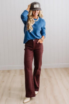 Blonde woman in a plaid hat wearing a solid waffle texture sweater with drop shoulder seams and crewneck.