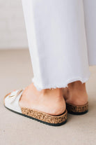 Cork sole sandals with white faux leather straps and gold buckle accent.