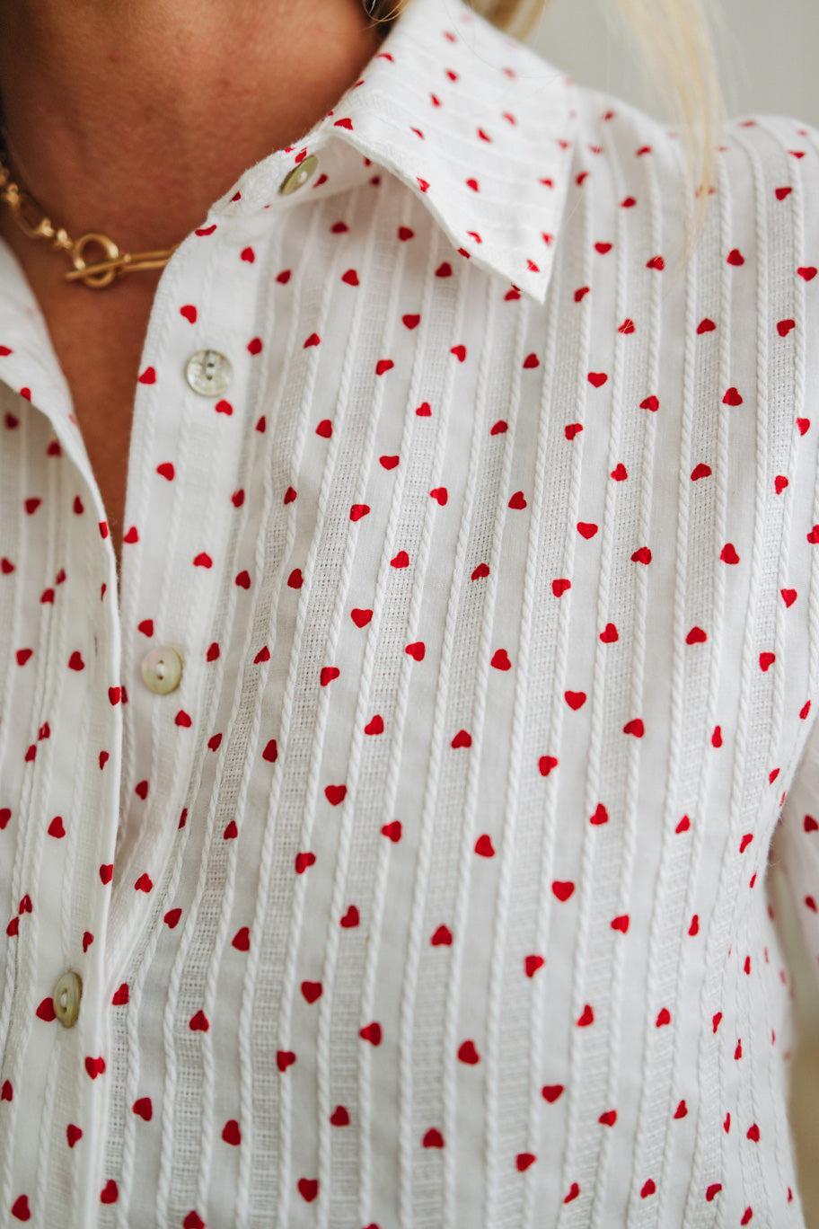 White shirt with red heart patterns worn by a person