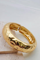 Close up of a shiny gold bangle
