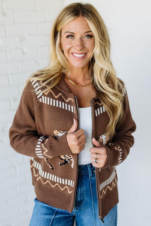 Woman wearing a brown patterned cardigan against a white background