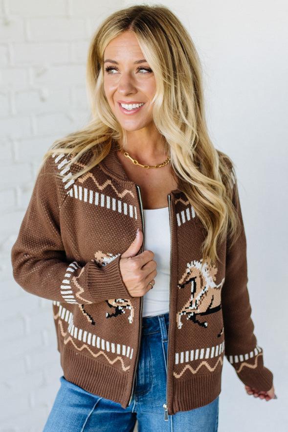 Woman wearing a brown patterned cardigan against a white background