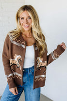 Woman wearing a brown cardigan with horse patterns against a white background