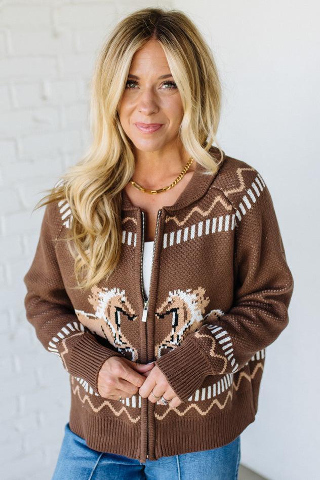 Woman wearing a brown patterned sweater against a white background