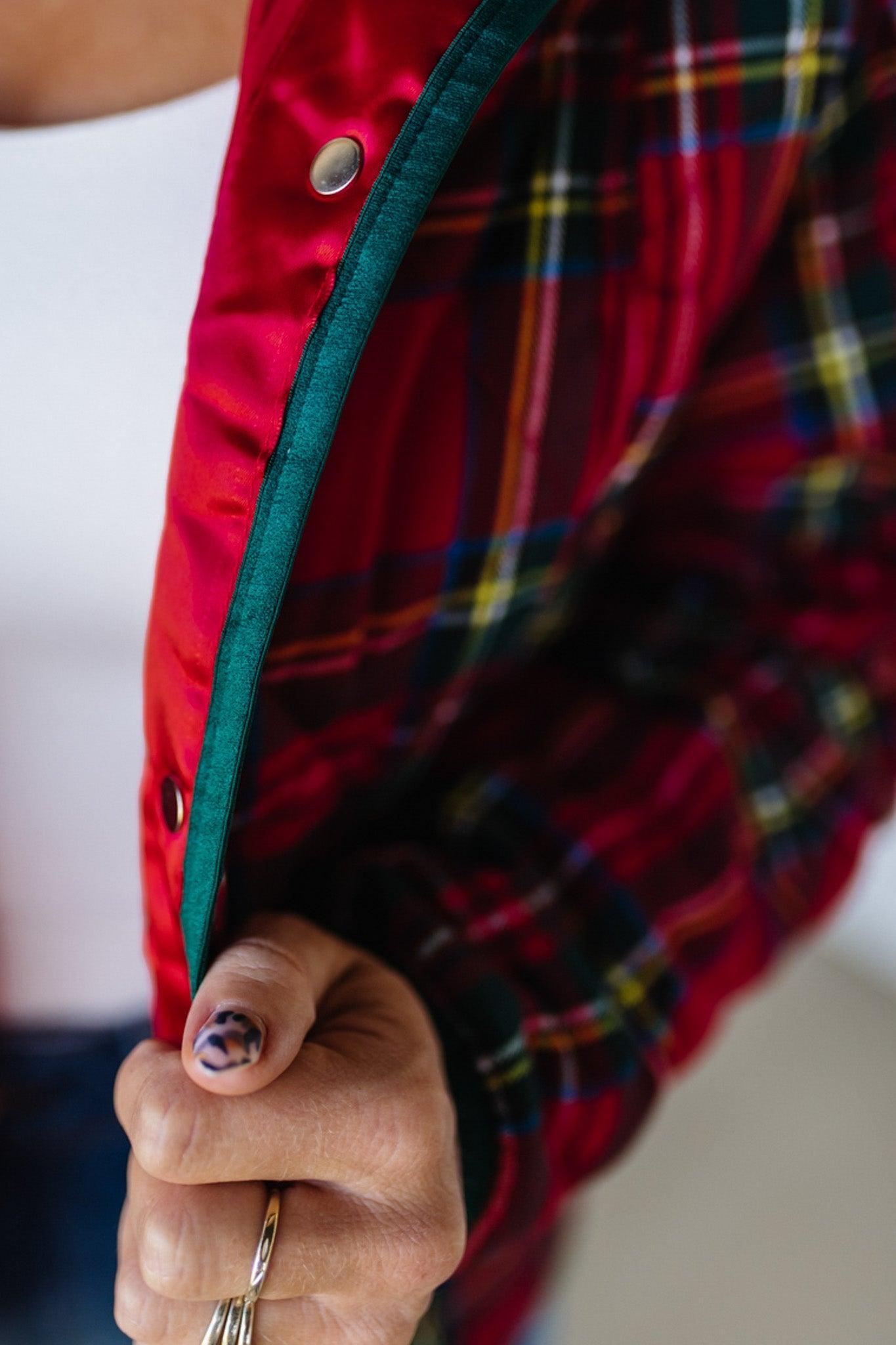 Close-up of a person wearing a red plaid jacket with a white background