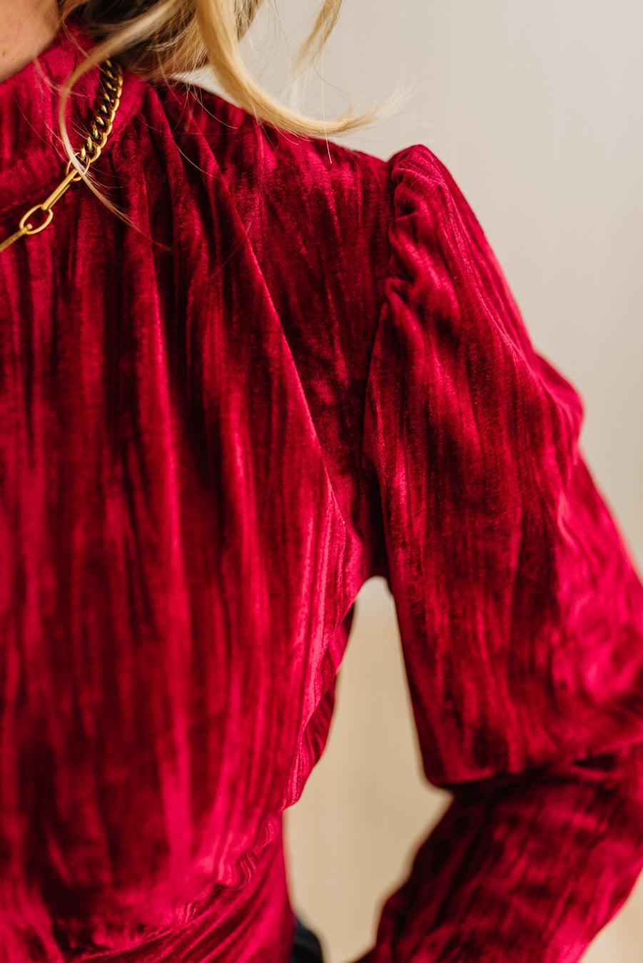 Close-up of a person wearing a red textured dress with a blurred background