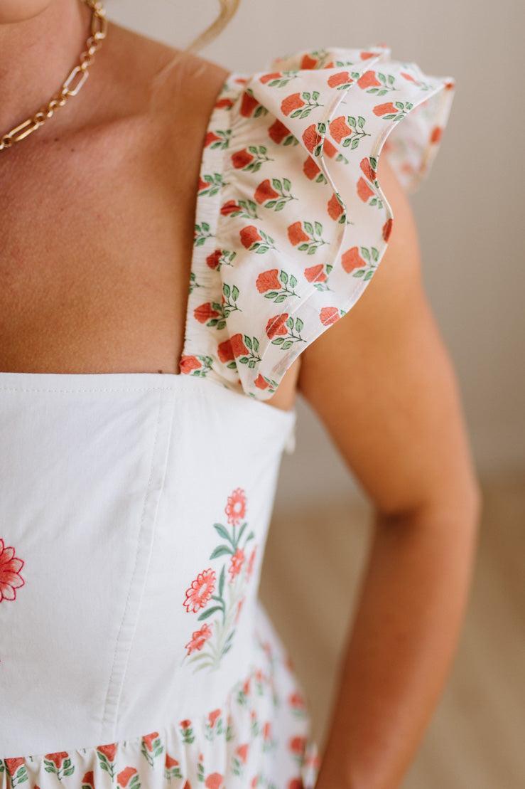 Close-up of a person wearing a floral dress with a neutral background