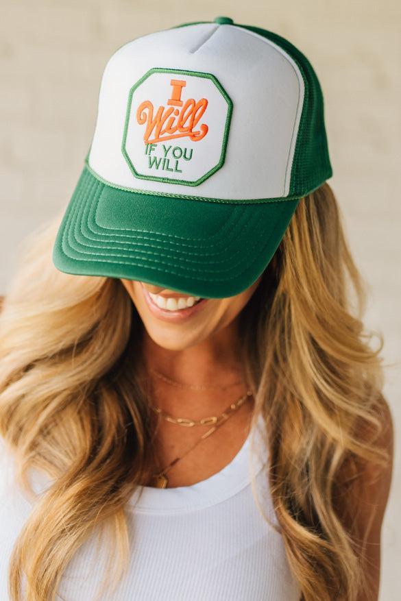 Blonde woman wearing a green mesh back trucker hat with white panel front, and a patch at the center that says "I Will If You Will" with red accent embroidery.