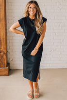 BLONDE WOMAN WEARING A BLACK ROUND NECK SHORT SLEEVE MIDI DRESS WITH SIDE SLIT.