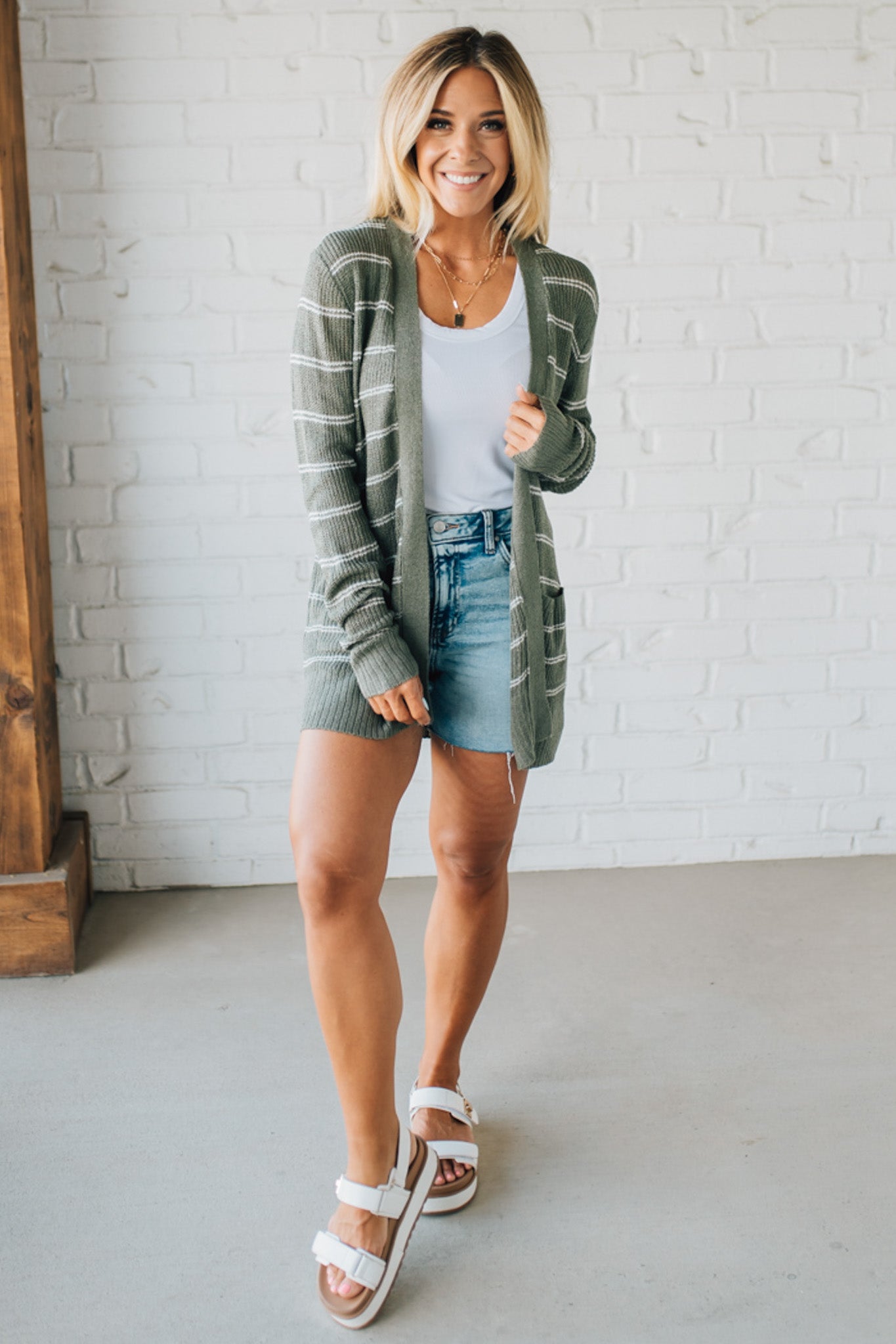 Blonde woman wearing a Breezy Knit Striped Cardigan with Pockets.