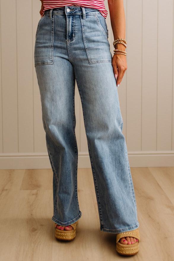 Person wearing blue jeans and a striped shirt against a neutral background