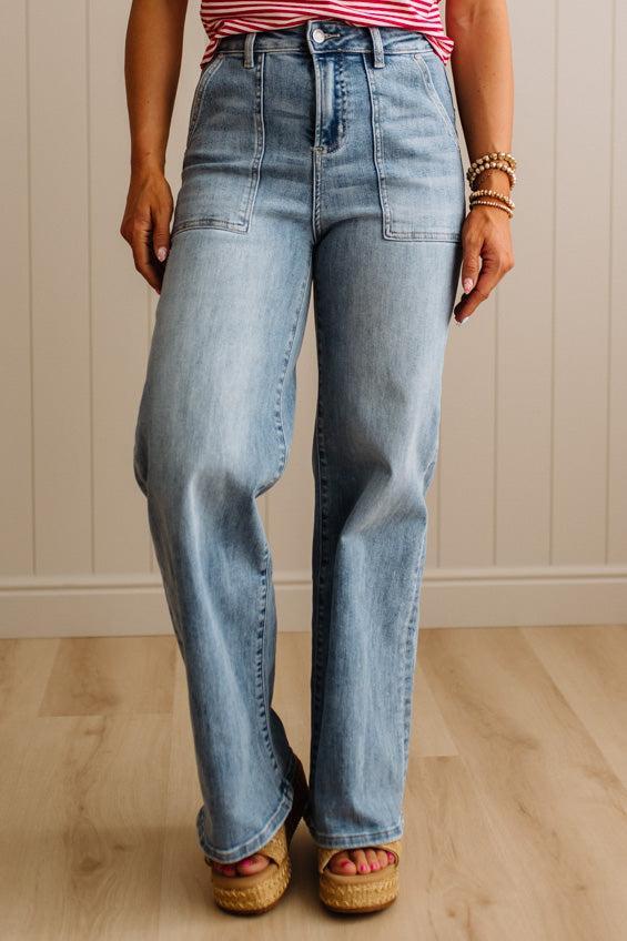 Person wearing light blue jeans and a striped shirt indoors.