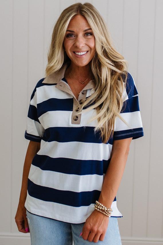 Woman wearing a navy and white striped shirt with a beige collar.