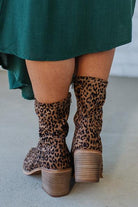 Person Wearing Leopard print, side zipper Sleek Ankle Hugging Booties with a green skirt.