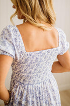 Woman wearing a floral dress with a plain background