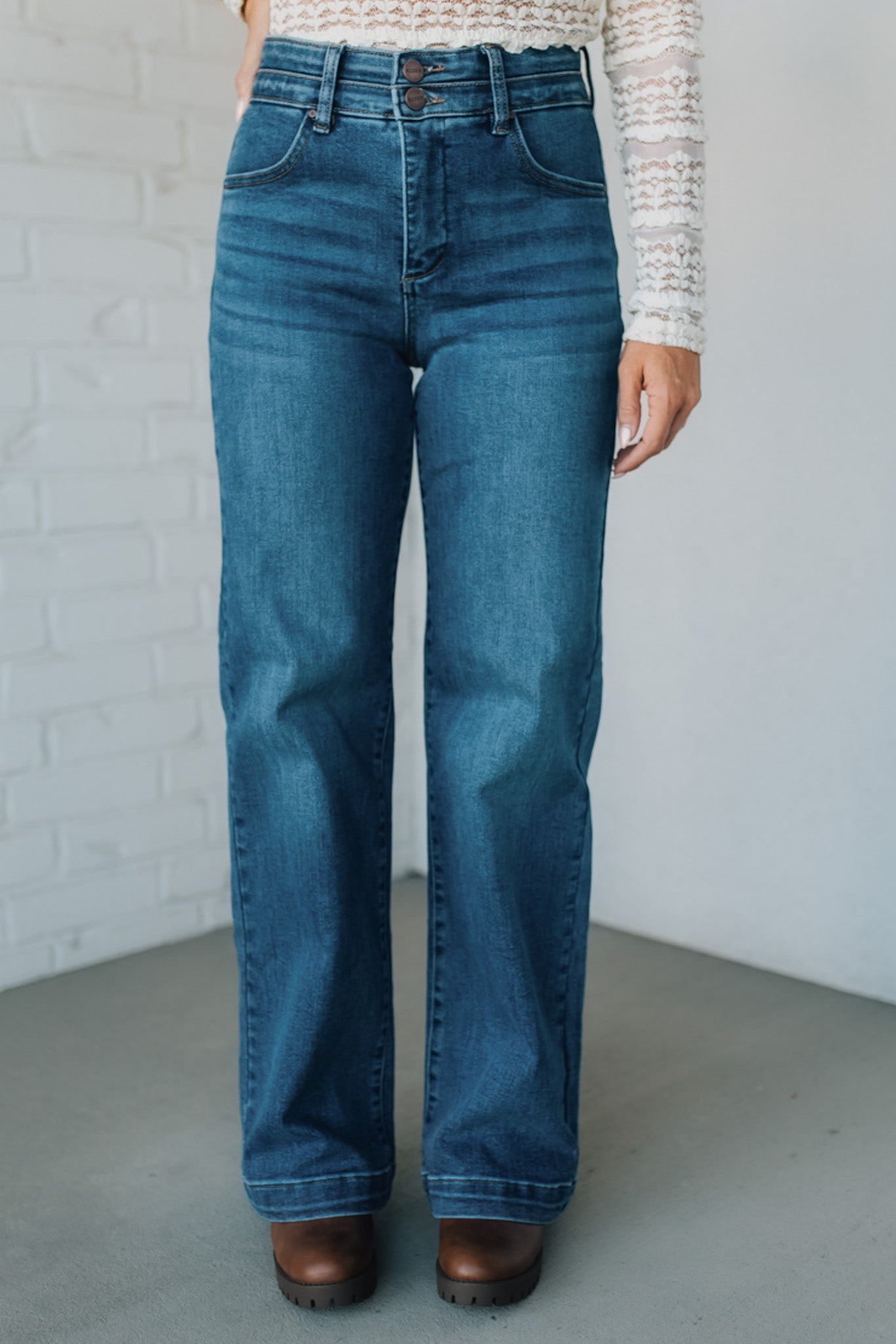 Person wearing blue jeans against a plain background