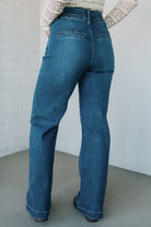 Person wearing blue jeans against a plain background