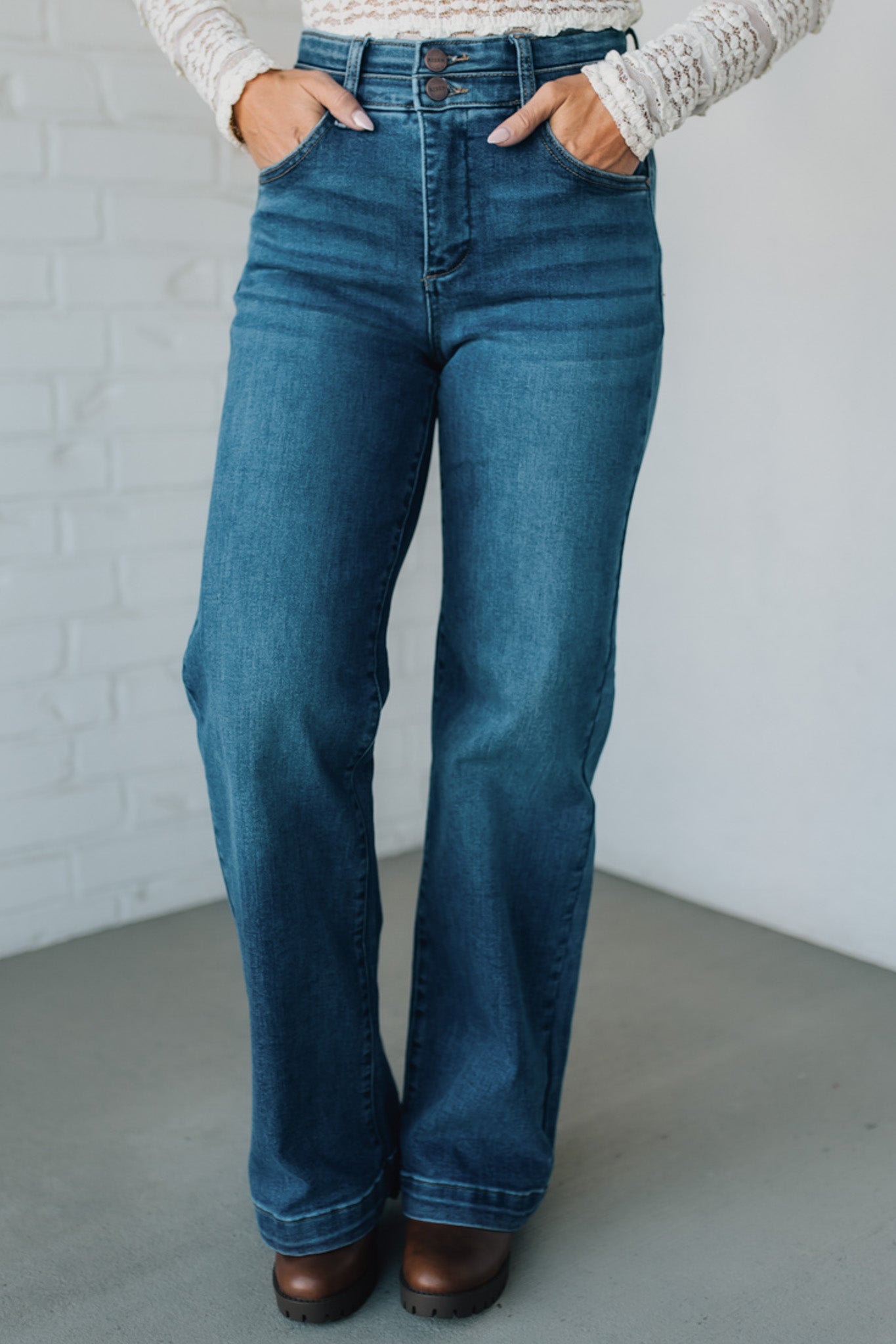 Person wearing blue jeans with a plain background