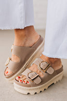 TAUPE PLATFORM SANDAL WITH TWO STRAPS FEATURING A LARGE GOLD BUCKLE ON EACH.