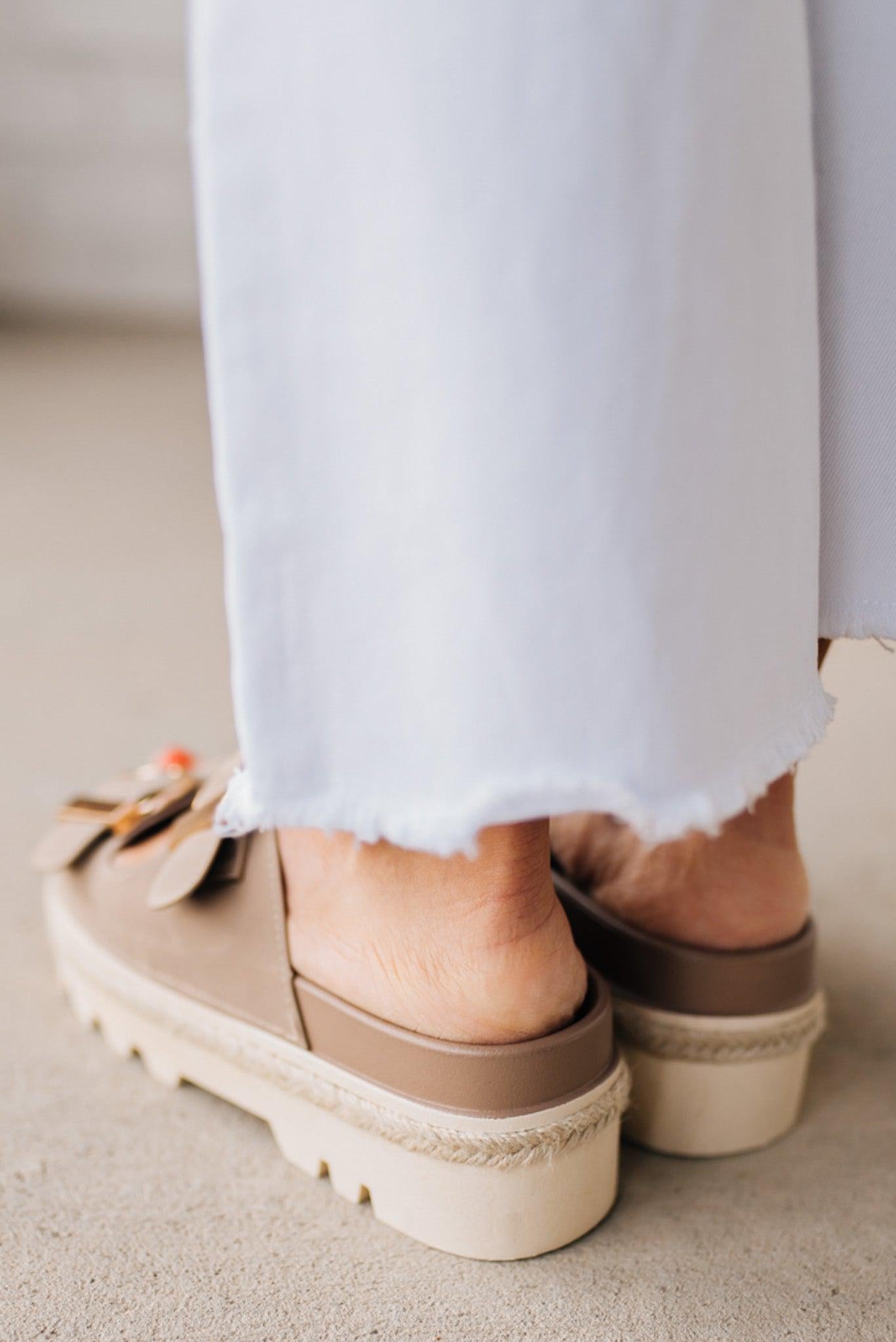 TAUPE PLATFORM SANDAL WITH TWO STRAPS FEATURING A LARGE GOLD BUCKLE ON EACH.