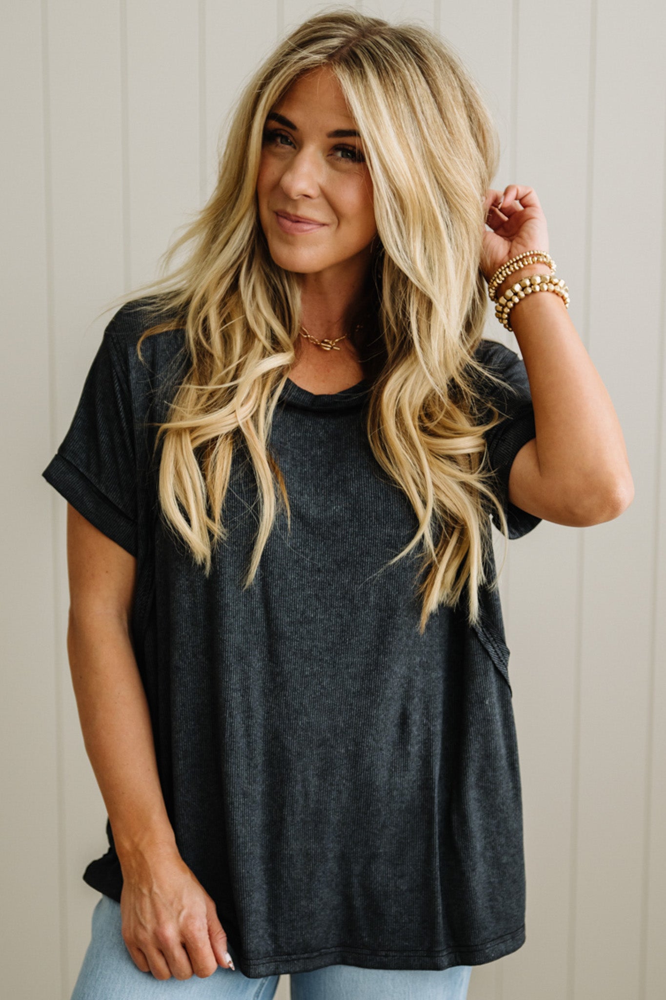 Woman wearing a black t-shirt with a neutral background