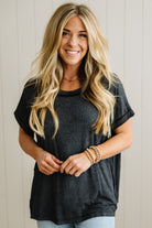 Woman wearing a black t-shirt and blue jeans with a neutral background