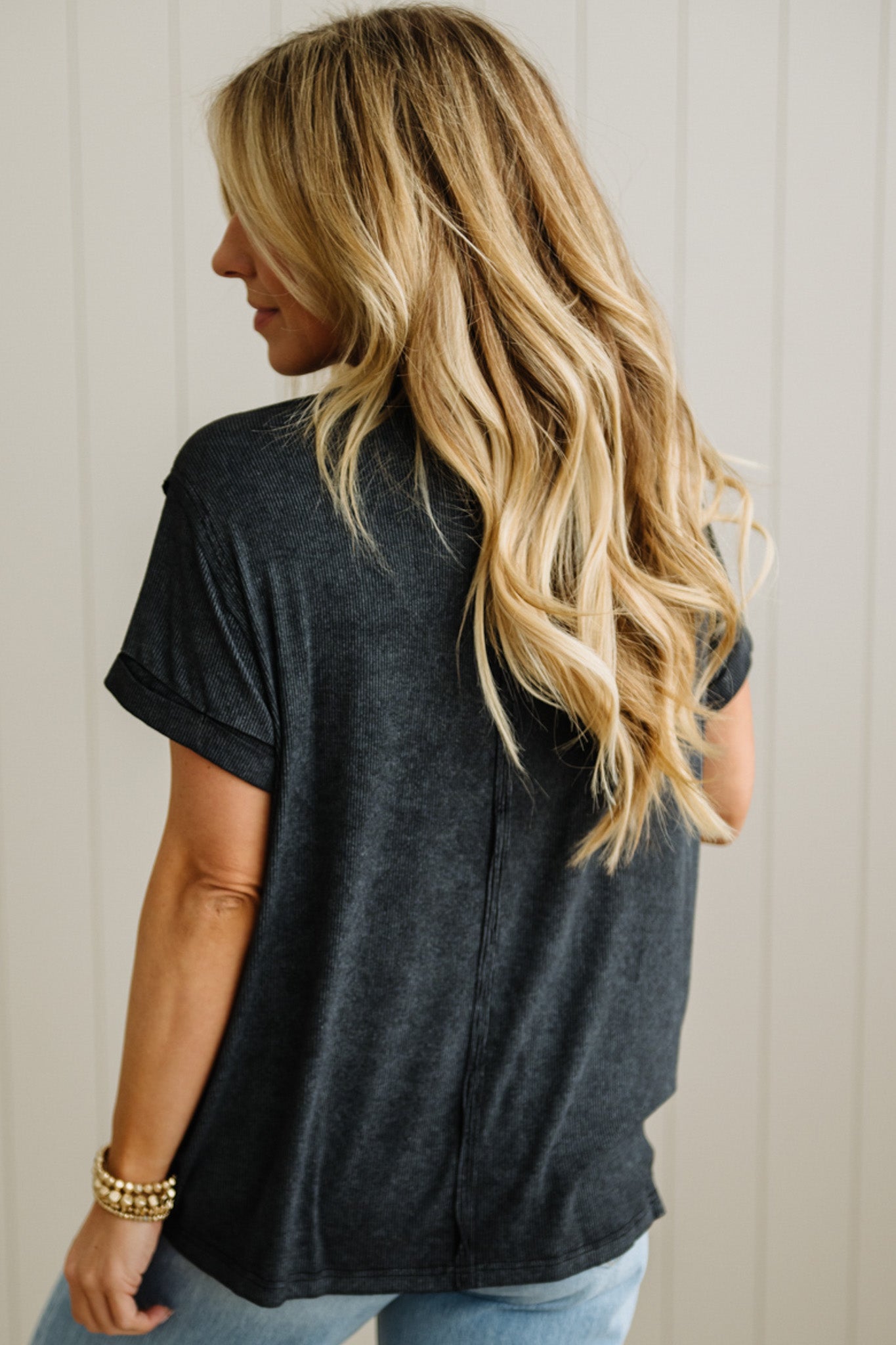 Woman wearing a black t-shirt with a neutral background