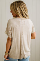 Woman wearing a beige t-shirt with a plain background
