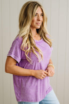 Woman wearing a purple t-shirt against a plain background