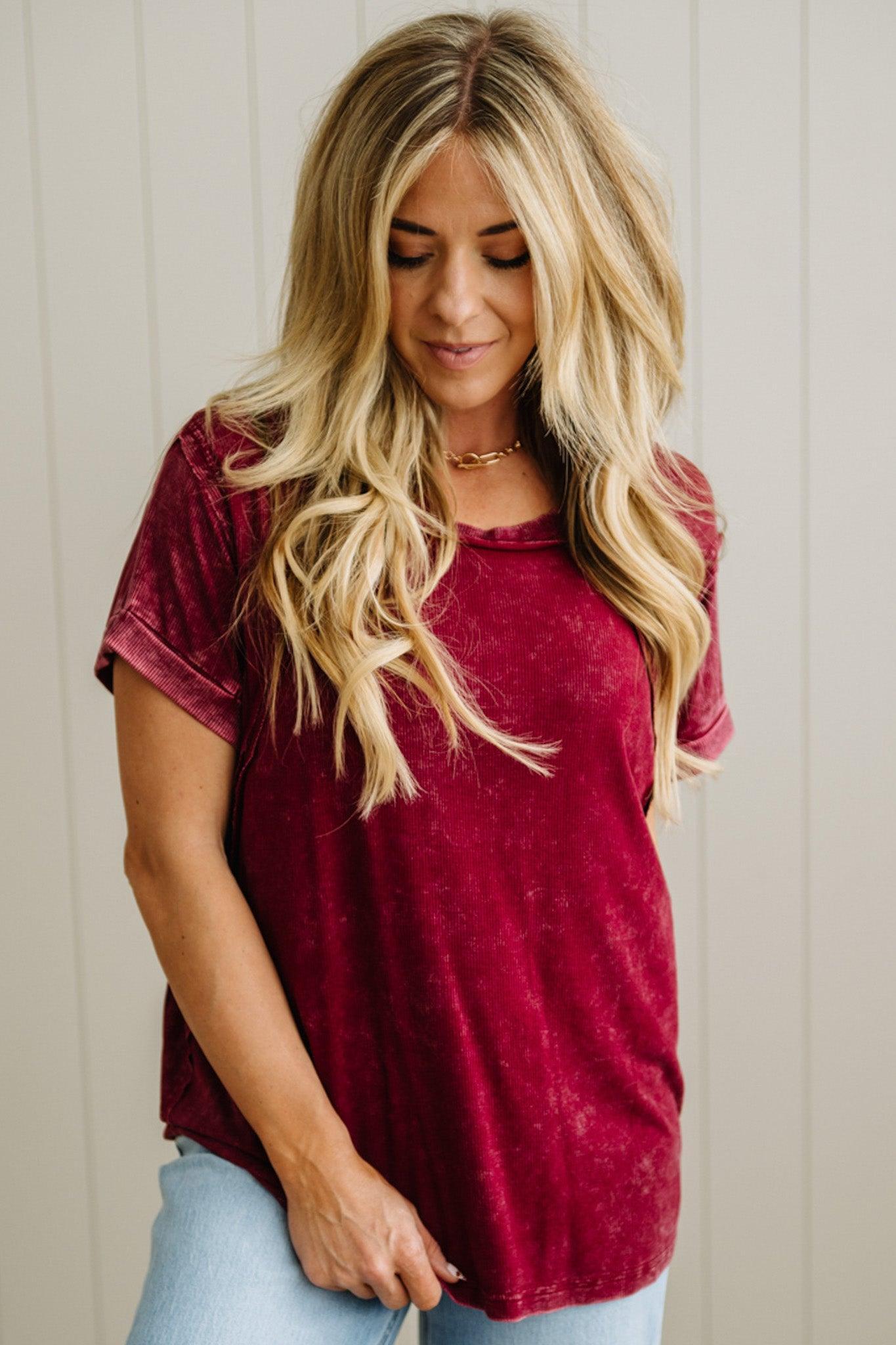 Woman wearing a maroon t-shirt against a neutral background