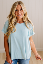 Woman wearing a light blue t-shirt and jeans indoors