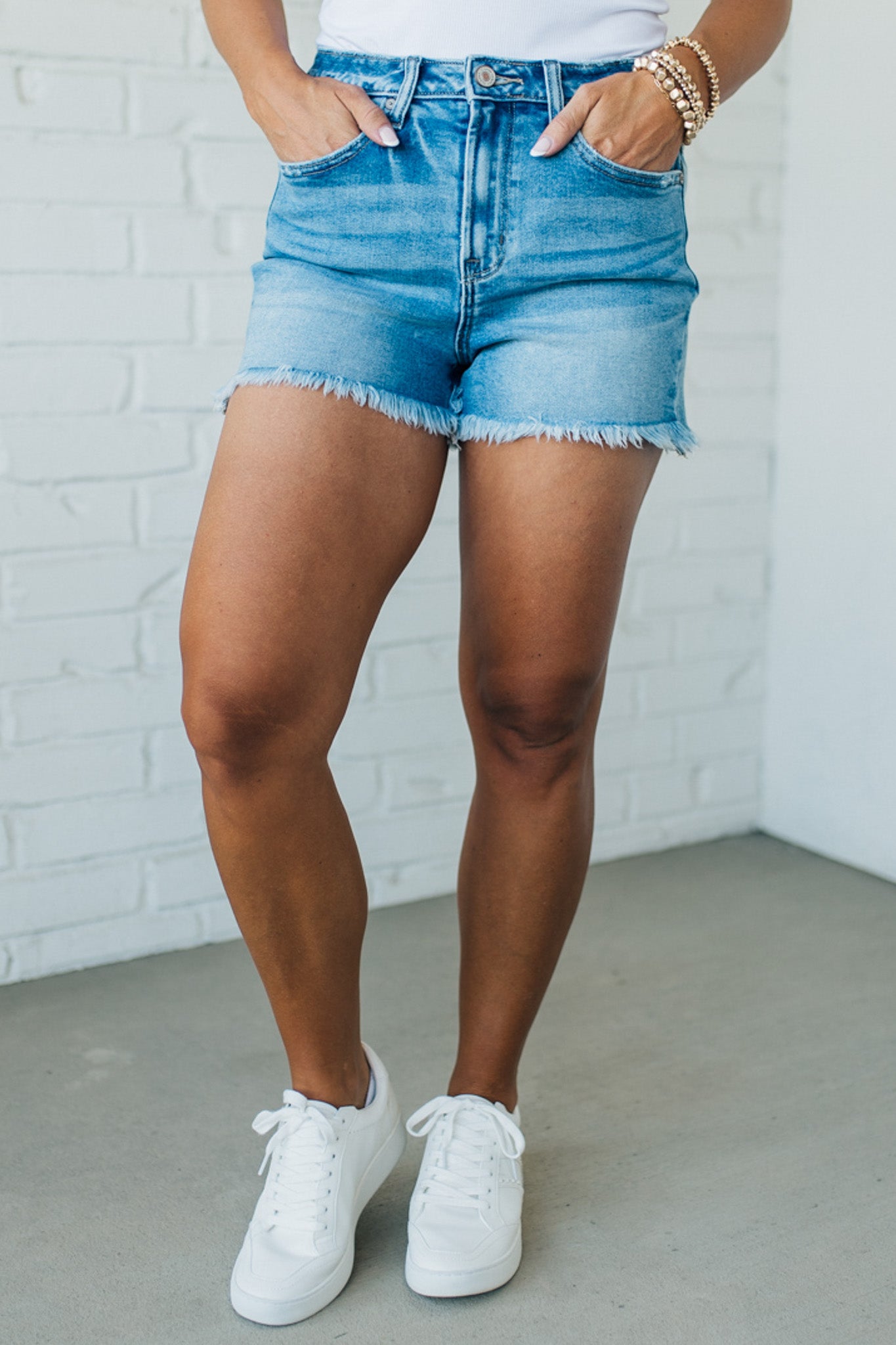 Blonde woman wearing medium wash denim cut off shorts