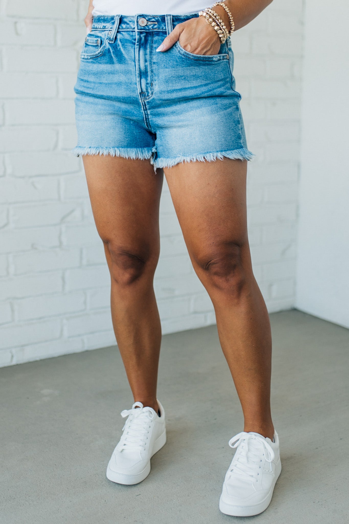 Blonde woman wearing medium wash denim cut off shorts