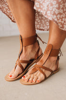 COGNAC BROWN FLAT FAUX LEATHER SANDALS WITH TIE BACK.