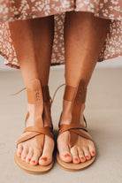 COGNAC BROWN FLAT FAUX LEATHER SANDALS WITH TIE BACK.