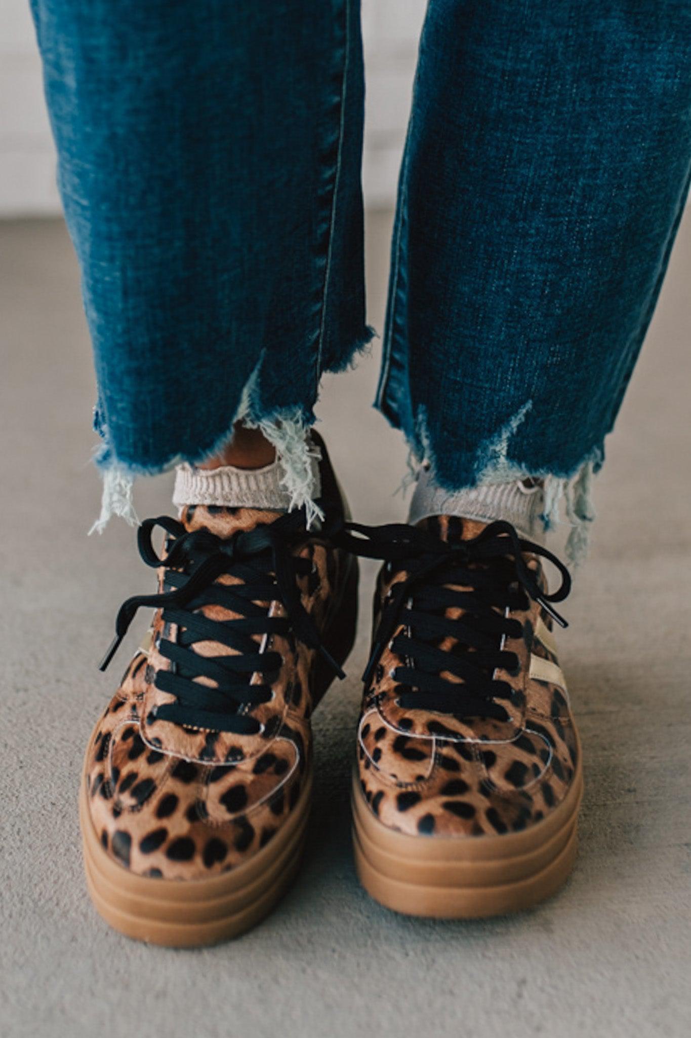 Leopard print sneakers with gold accents and black laces.